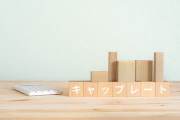 キャップレートと書かれたブロック、電卓、不動産の模型