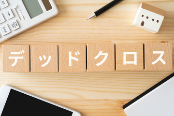 デッドクロスと書かれたブロック、電卓、スマホ、建物の模型