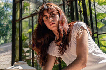 Naklejka premium Young latin woman posing in botanical garden setting