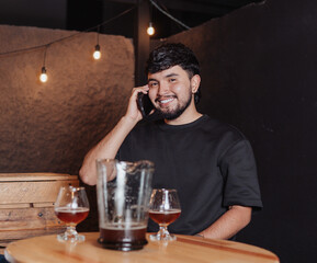 Latin man smiling while talking on cell phone in a bar