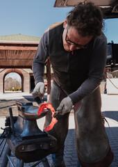 Obraz premium Blacksmith forging horseshoe on anvil