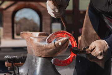 Blacksmith forging horseshoe on anvil