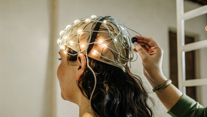 A medium closeup capturing the moment of activation as a neural interface headset pulsates with light while making contact with the human brain suggesting a dynamic relationship