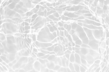 White water with ripples on the surface. Defocus blurred transparent white colored clear calm water surface texture with splashes and bubbles. Water waves with shining pattern texture background.