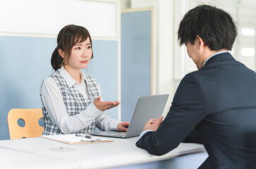 Obraz premium 接客・顧客対応する受付嬢・事務員の女性と顧客の男性 