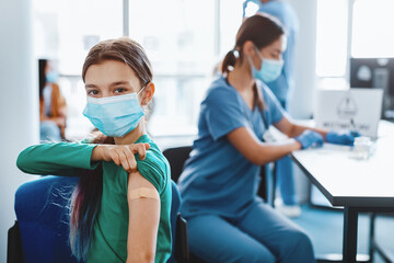 flu Vaccination Concept. Happy Adolescent Girl In Surgical Mask Showing Vaccinated Arm With...