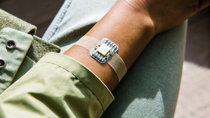 A closeup of a skin patch with microchip technology embedded positioned on a persons wrist showcasing innovative wearable tech that tracks health metrics in realtime.