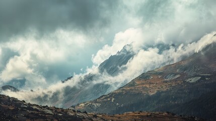 Naklejka premium Clouds Surrounding Mountain Peaks Create a Dreamy Atmosphere