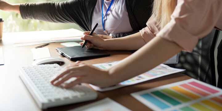 Graphic design team collaborating on a project with digital tools in a creative workspace.