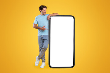 Mobile App Advertisement. Full Body Length Of Happy Man Leaning And Pointing At Big Huge White...