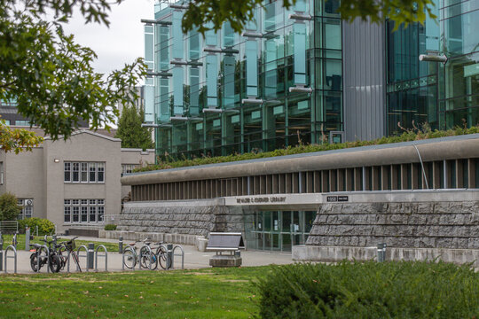 Vancouver, CANADA - Sep 30 2024 : The Walter C. Koerner Library at the University of British Columbia features a modern glass facade, landscaped rooftop, and bike racks in a green campus setting.