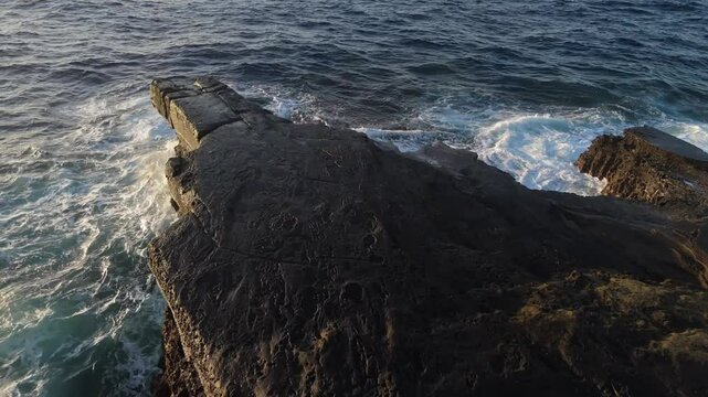Aerial view of waves crashing on rocks shore in Hawaii