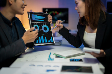 Two people are looking at a chart on a table