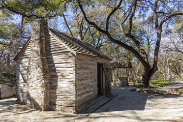 old wooden log cabin with stone chimney