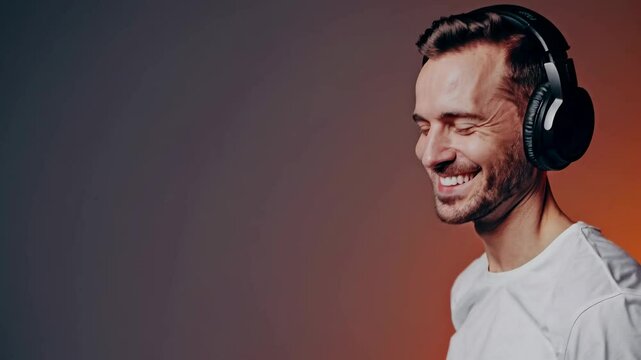 A joyful man in headphones smiles with eyes closed. Shot from a front angle, the video captures a warm, relaxed vibe with soft lighting.