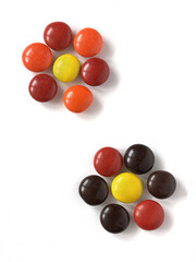 Round multicolored candies isolated on white background arranged in the shape of flowers. Bonbon sweets, dragee 