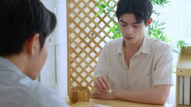 Asian young men playing board game Go during competition in community.