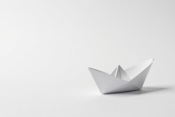 A solitary, meticulously folded paper boat rests on a pristine white surface, symbolizing simplicity, hope, and the boundless potential of a blank canvas