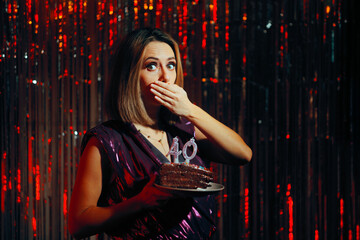 Funny Shocked Woman Holding Cake Turning 40 years Old. Millennial girl reaching an age milestone with humor and grace
