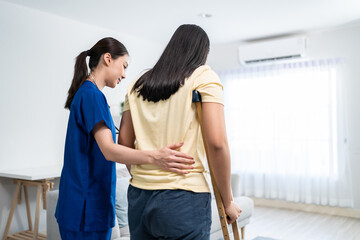 Asian female leg amputee doing physiotherapy with support from nurse. 