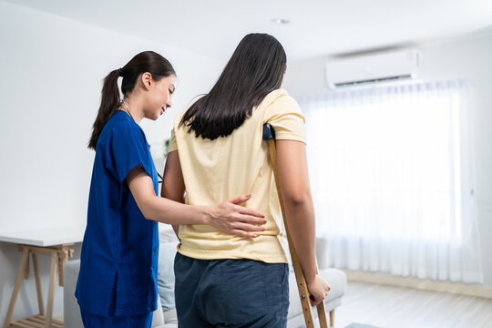 Asian female leg amputee doing physiotherapy with support from nurse. 