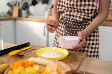 Close up of woman cooking healthy foods in kitchen in morning at home. 