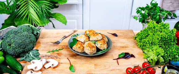 Baked chicken and turkey cutlets or meatballs with yellow paprika on kitchen table.