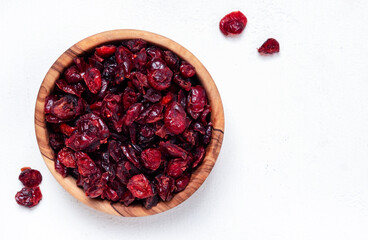 Organic sun dried cranberries in bowl on white background, top view