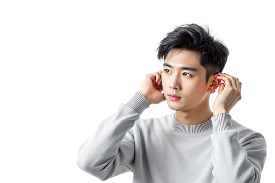 Young man wearing a gray sweater adjusting his ears with both hands, looking to the side. Isolated on white background. Concept of hearing or focus. Ai generative