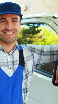 Smiling handyman leaning against his van