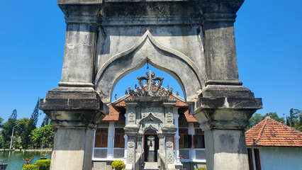 The building has a large archway and is surrounded by trees