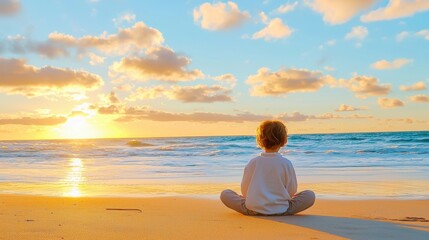 Fototapeta premium A child sits peacefully on the beach, watching a vibrant sunset over the ocean, creating a serene and contemplative atmosphere.