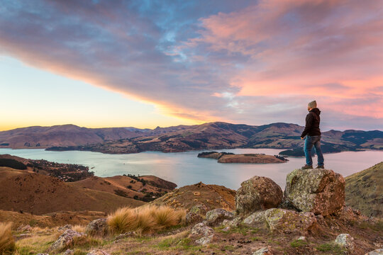 Man looking at view at sunrise, Littleton bay, Christchurch, New Zealand