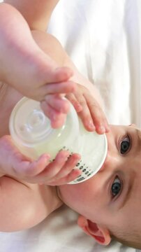 Cute baby lying and drinking his baby's bottle