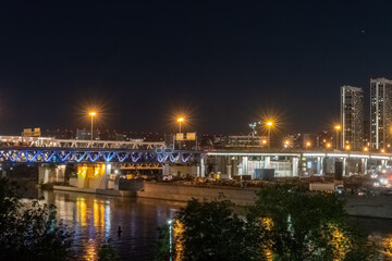 Obraz premium The scyscrapers of the Moscow City at night and the Dorogomilovsky bridge with illumination. Translation of text - street names: Krasnopresnenskaya, center, etc.