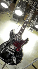 Black electric guitar studio photoshoot, bright lights background, music instrument photography for website or magazine