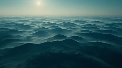 Obraz premium Serene Aerial View of Undulating Mountains and Mist Under a Soft Morning Sunlight in Hazy Atmosphere