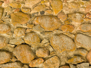 An old stone wall. Background of yellow stones. Stone texture. Yellow stones.