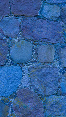 An old stone wall. Masonry. Background of blue stones. The texture of the stone. Vertical image.