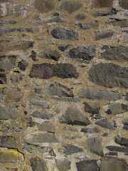 An old stone wall. Masonry. Background of grey stones. The texture of the stone. Vertical image.