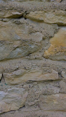 An old grey stone wall. Grey stone background. Vertical image. Stone texture. Masonry.