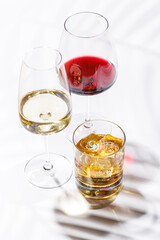 A refined composition of wine glasses filled with red and white wine, paired with a whiskey glass