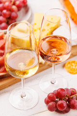 A delectable arrangement of various cheeses, fresh grapes, prosciutto and wine