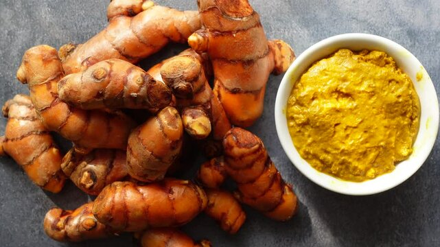 Turmeric roots and fresh turmeric paste preparation in kitchen