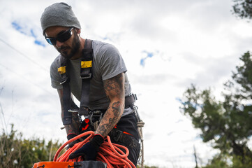 Tree surgeon preparing climbing rope for tree pruning
