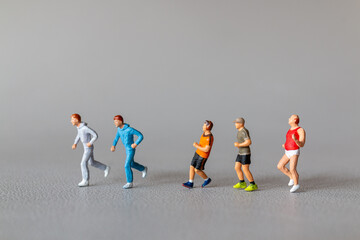 Close-up of tiny figurines of runners in colorful sportswear, depicting an active lifestyle....