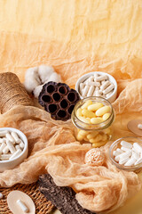 Food supplements in forms of tablets, pills and capsules on beige background in rustic style. Dietary supplements, vitamins and minerals for healthy lifestyle.