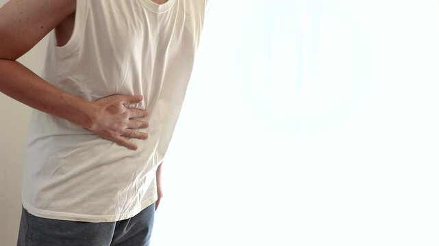 片手で胃のあたりをさする男性