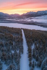 Snowy Winter Landscape with Aerial View of Forest and Mountain Sunset Over Frozen Lake, Perfect for Travel and Nature Photography Needs
