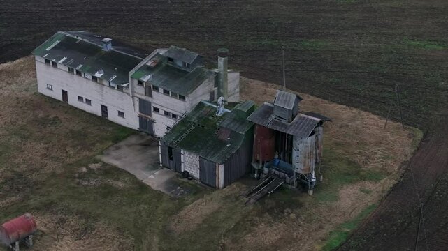 Old farm facility with rusting metal and broken structures, evoking decay, drone